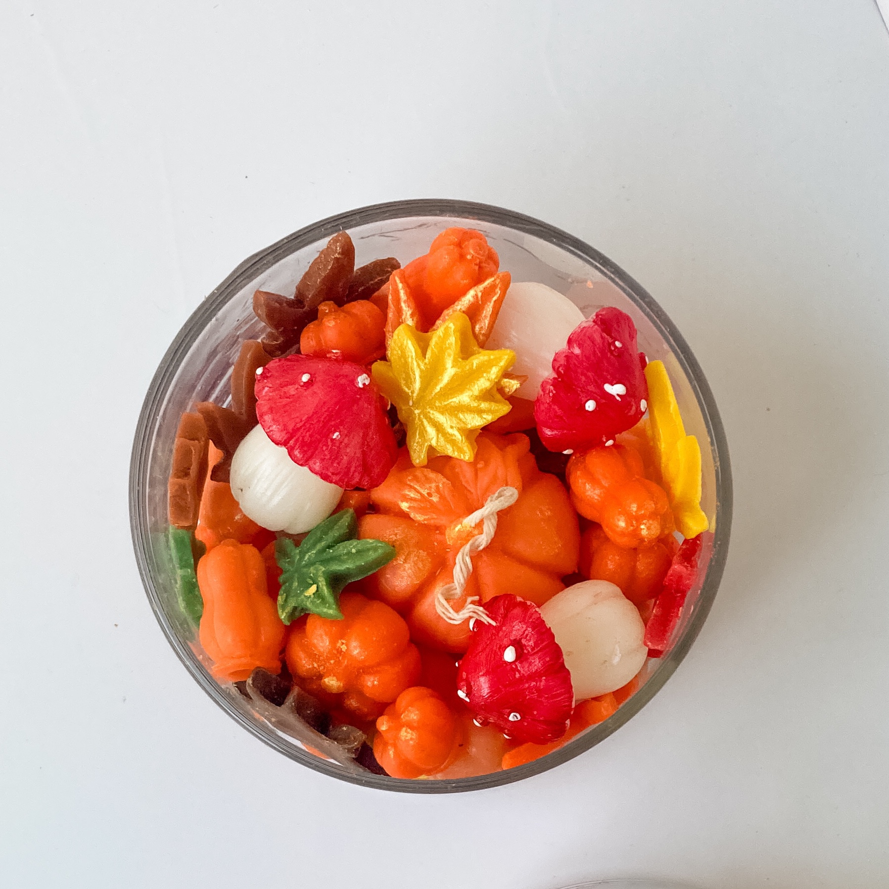 شمع شیشه ای پاییزه شامل کدو قارچ و برگ های پاییزه